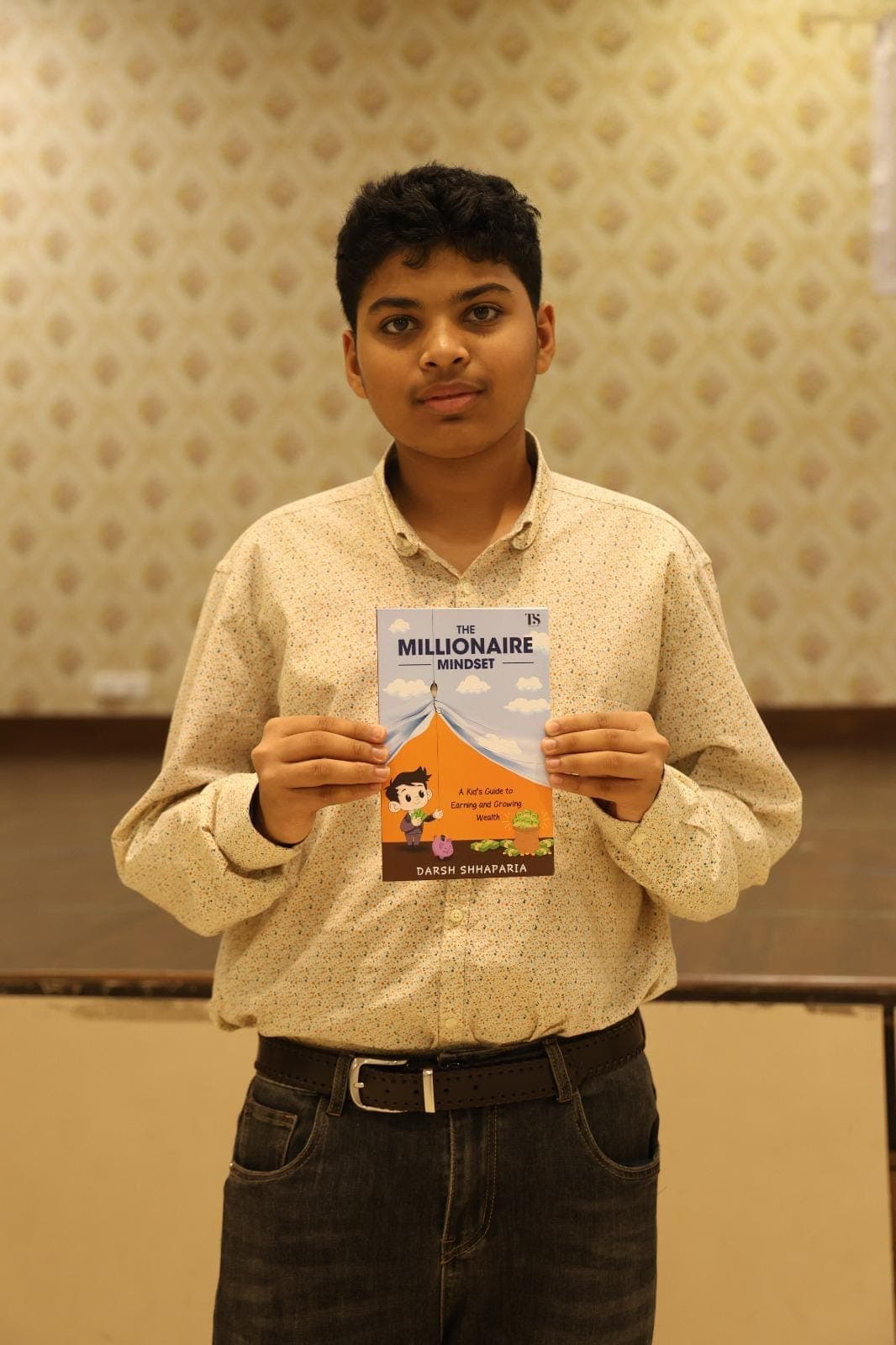 Darsh Shhaparia holding a copy of The Millionaire Mindset