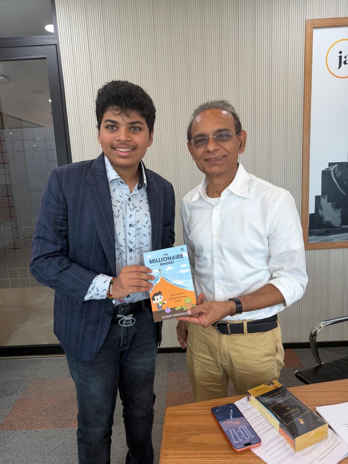 Darsh Shhaparia presenting a copy of The Millionaire Mindset